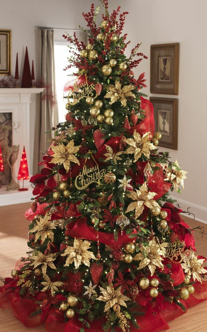 A lavishly decorated Christmas tree with gold poinsettias, red mesh ribbon, and twinkling lights